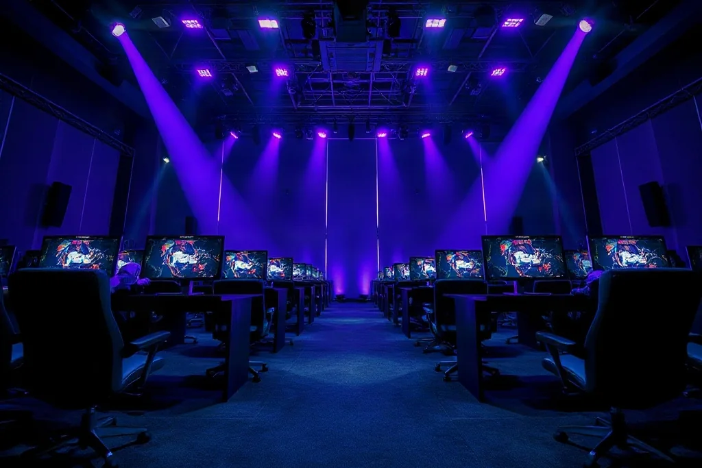 Esports tournament stage with two teams at computer stations under purple lights